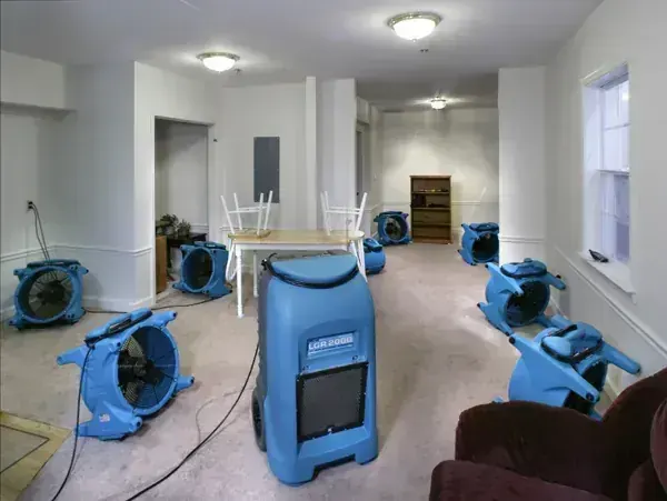 Air movers and an LGR dehumidifier drying a room after water damage in Aurora