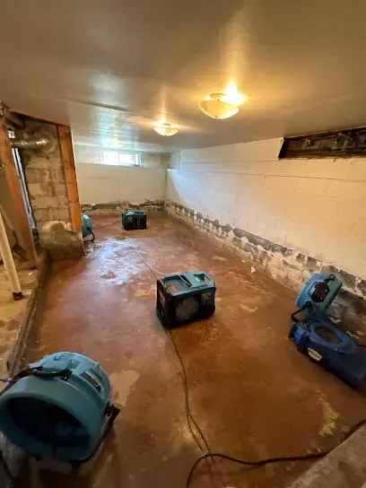 Air movers drying a basement floor after water damage in Aurora