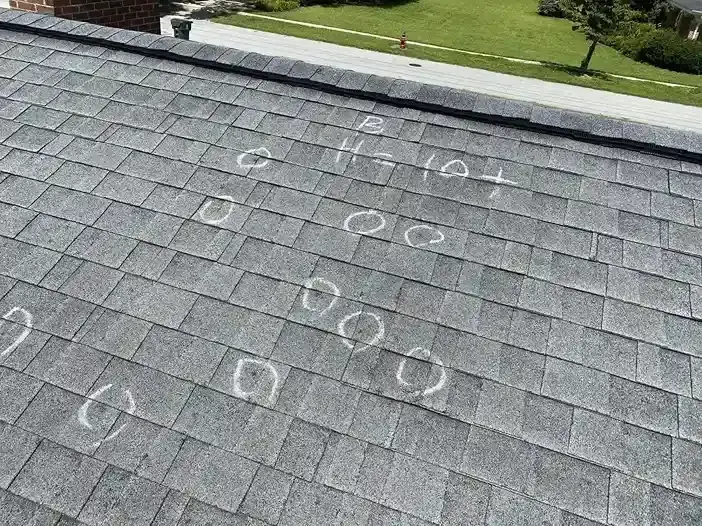 Storm-damaged roof shingles that let rain into an Aurora attic